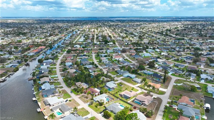 Aerial perspective of suburban area featuring a nearby body of water