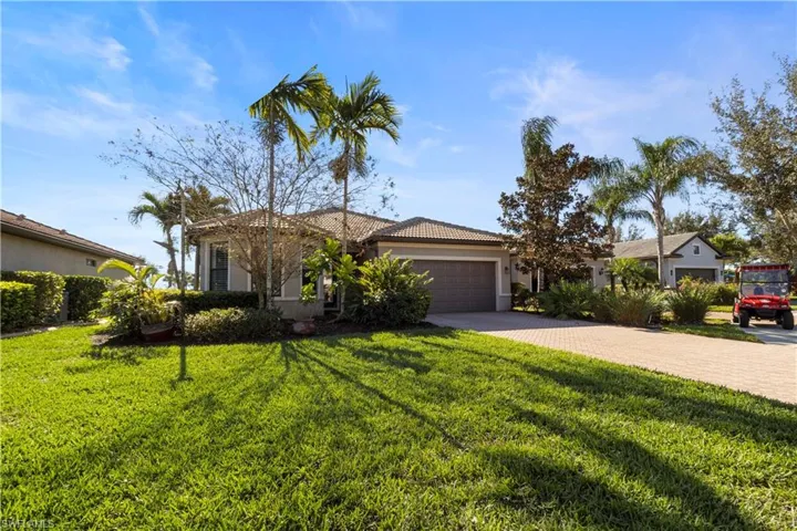 Ranch-style home with a front yard, decorative driveway, a garage, and a tile roof