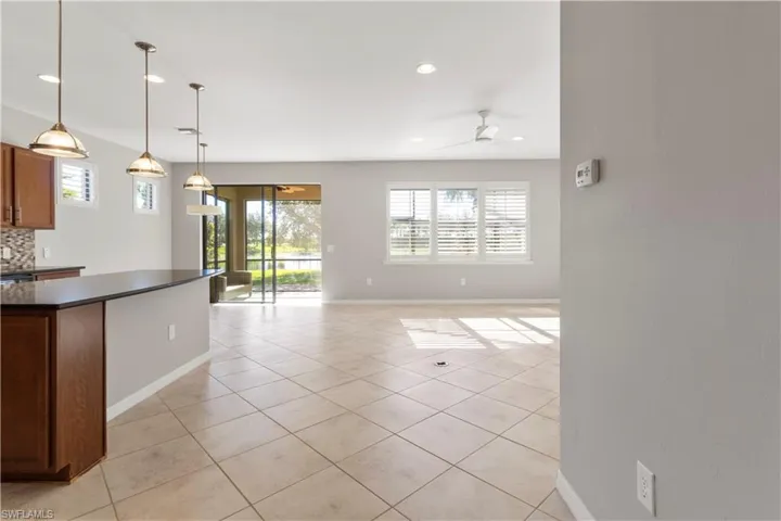 Kitchen featuring decorative light fixtures, light tile patterned floors, healthy amount of natural light, recessed lighting, and backsplash