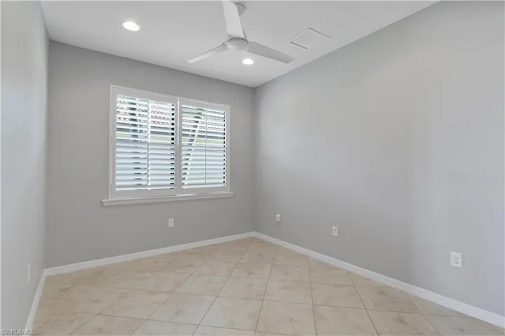 Empty room with a ceiling fan, recessed lighting, and light tile patterned flooring