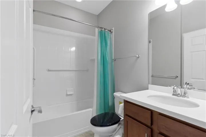 Full bath with vanity, shower / tub combo, and light tile patterned floors