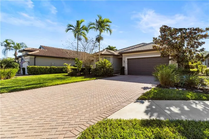 View of front of home with a tile roof, stucco siding, decorative driveway, and a garage