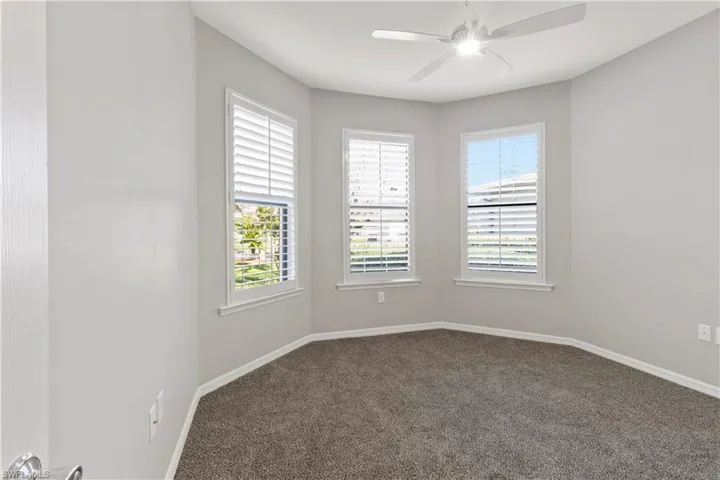Spare room featuring healthy amount of natural light, carpet flooring, and a ceiling fan