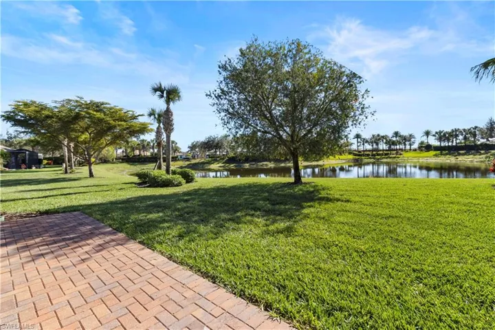 Surrounding community with a water view and a lawn