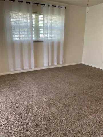 Unfurnished room with baseboards and carpet floors