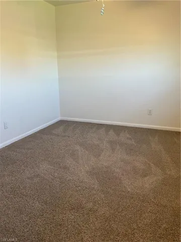 Carpeted spare room with baseboards