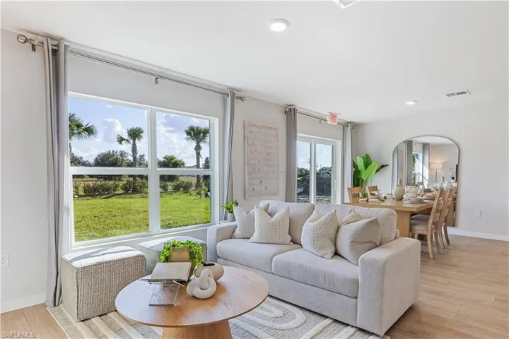MODEL HOME - Living area with light wood-type flooring, arched walkways, and recessed lighting