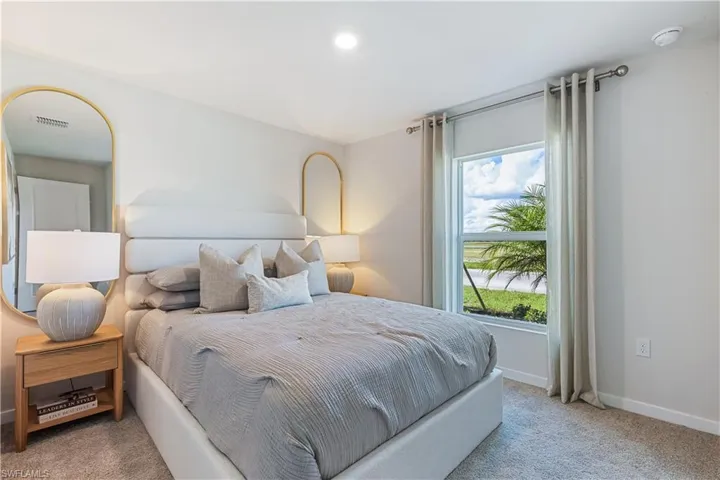 MODEL HOME - Bedroom featuring light carpet and baseboards