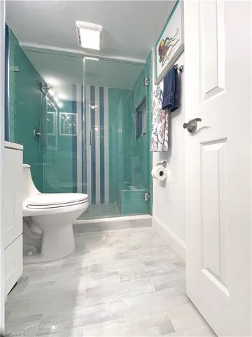 Bathroom featuring a shower stall and toilet