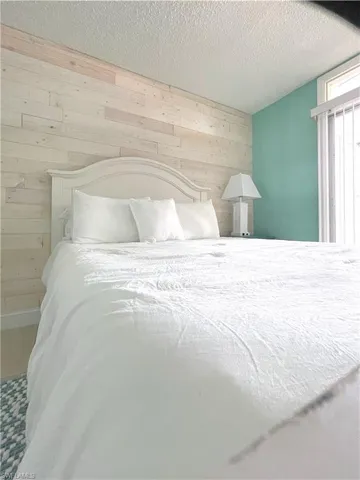 Bedroom featuring wood walls and a textured ceiling