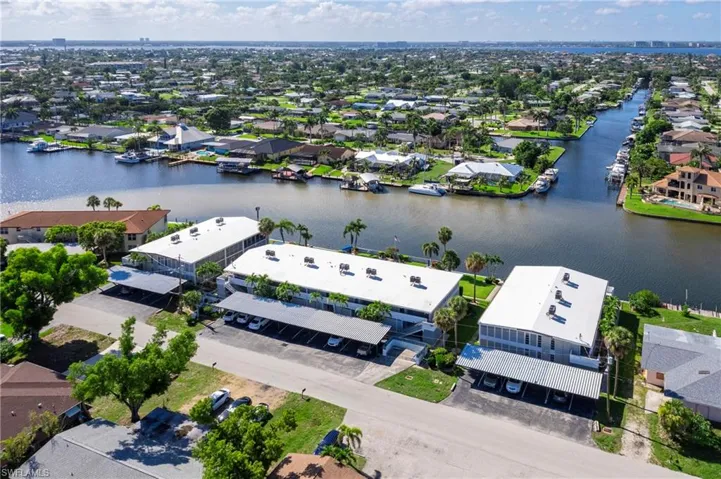 Aerial perspective of suburban area featuring a nearby body of water