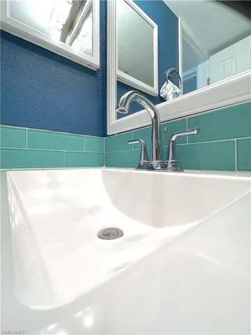 Bathroom view of a sink and a textured wall
