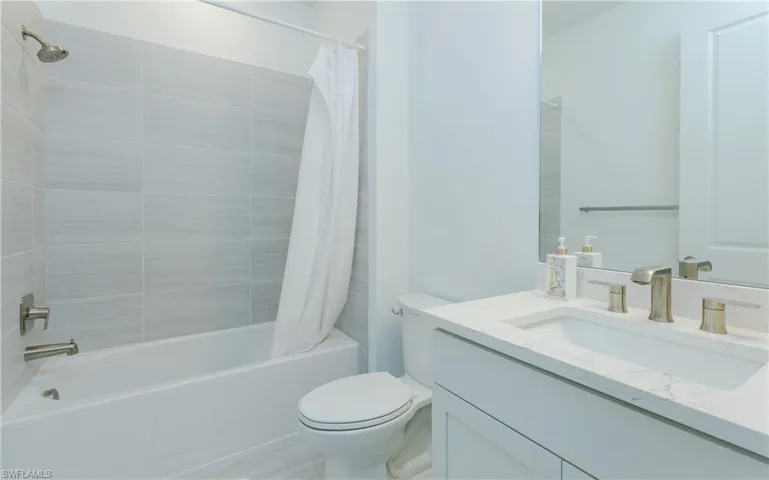 Bathroom with vanity and shower / bath combination with curtain