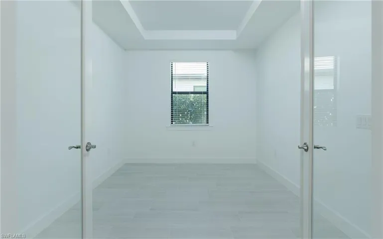 Unfurnished room featuring baseboards and a tray ceiling