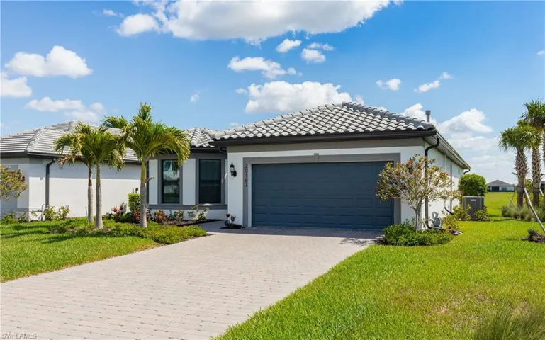 Single story home with a garage, a front yard, stucco siding, and decorative driveway