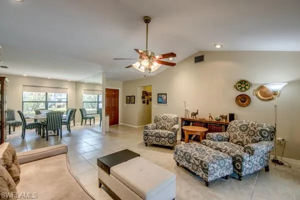 Tiled living room with lofted ceiling and ceiling fan