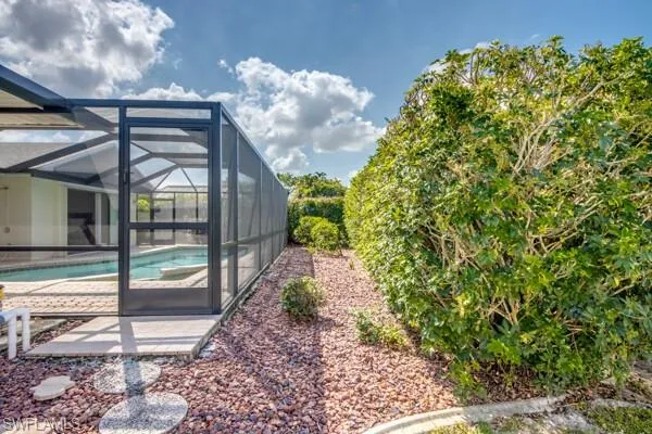 View of pool with a patio and glass enclosure