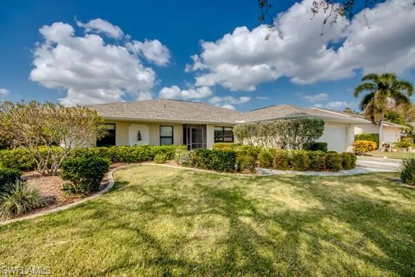 Ranch-style home with a front yard and a garage