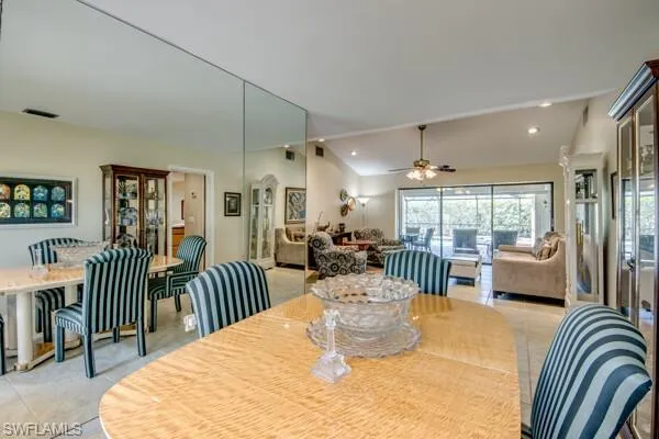 Dining room featuring ceiling fan, light tile patterned flooring, and lofted ceiling