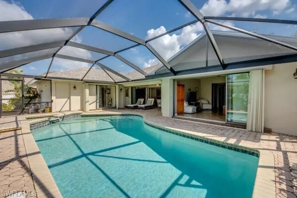 View of swimming pool with a patio and glass enclosure