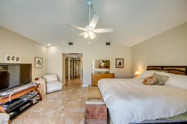 Bedroom featuring ceiling fan, vaulted ceiling, and light tile patterned floors
