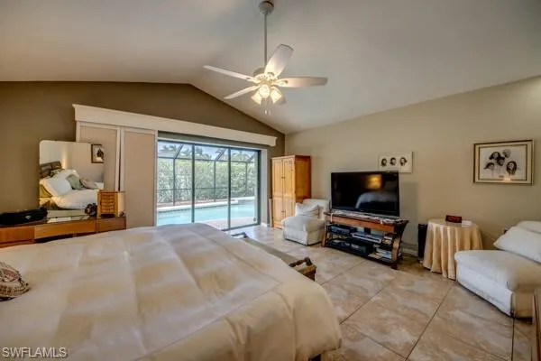 Tiled bedroom featuring ceiling fan, access to outside, and vaulted ceiling