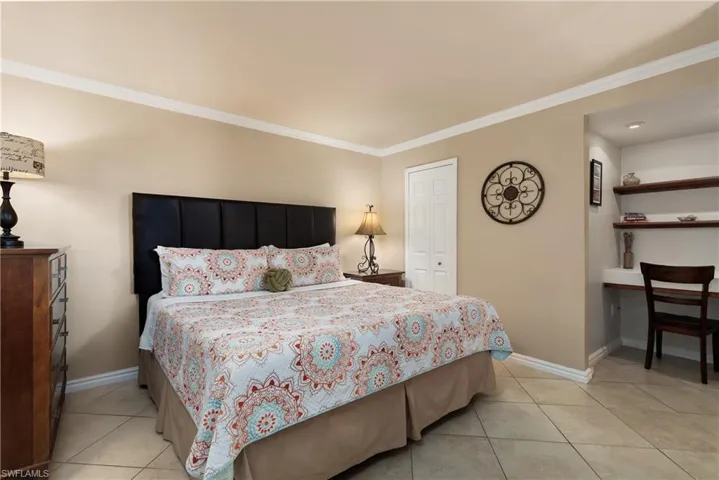 Bedroom featuring crown molding and light tile patterned floors
