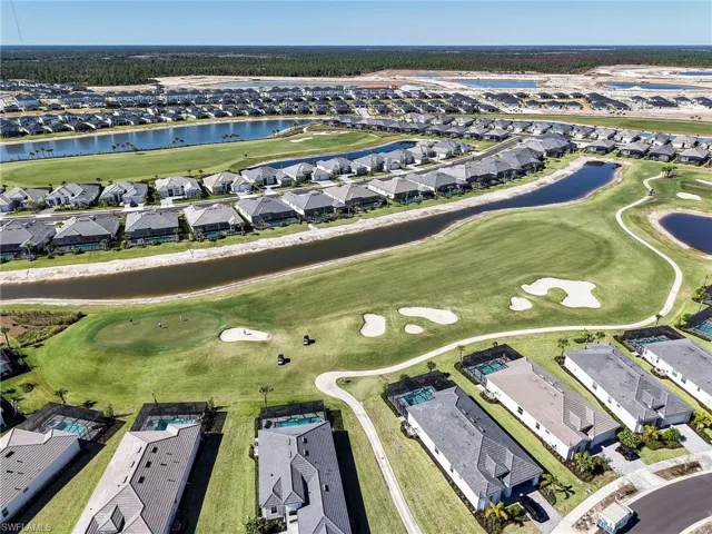 Aerial perspective of suburban area with a nearby body of water and a local golf course