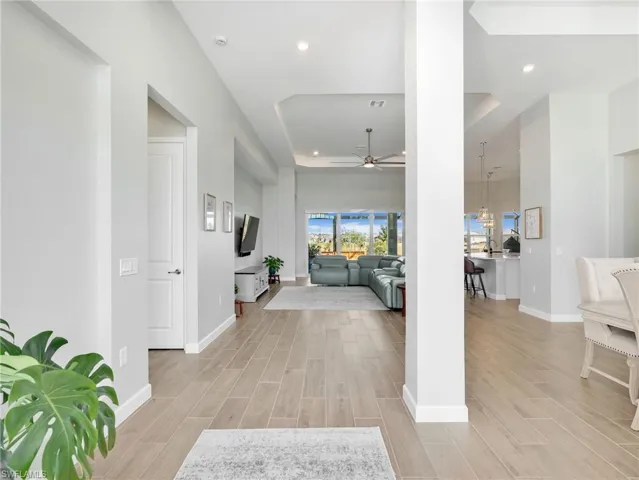 Foyer entrance featuring a raised ceiling, wood finish floors, recessed lighting, and a ceiling fan