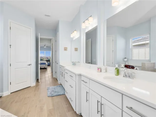 Bathroom featuring double vanity, wood tiled floors, and ensuite bath