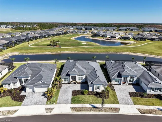 Aerial view of residential area featuring a large body of water and a golf club