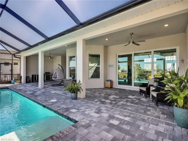 Outdoor pool with a patio, glass enclosure, and a sunroom