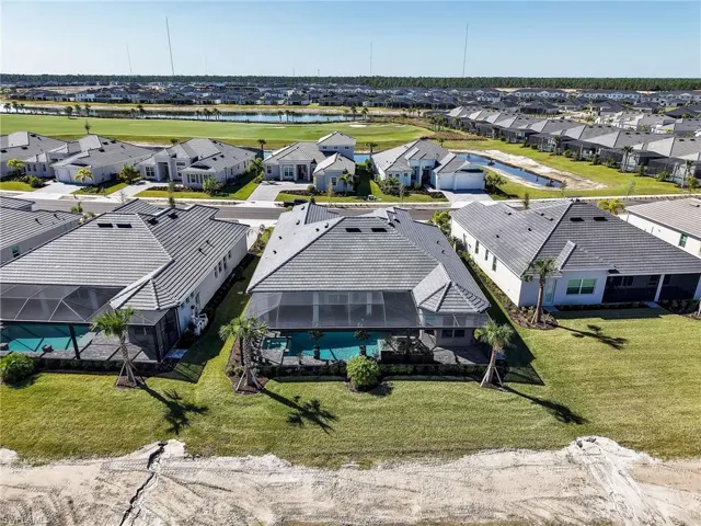 Aerial perspective of suburban area featuring a large body of water and a local golf course