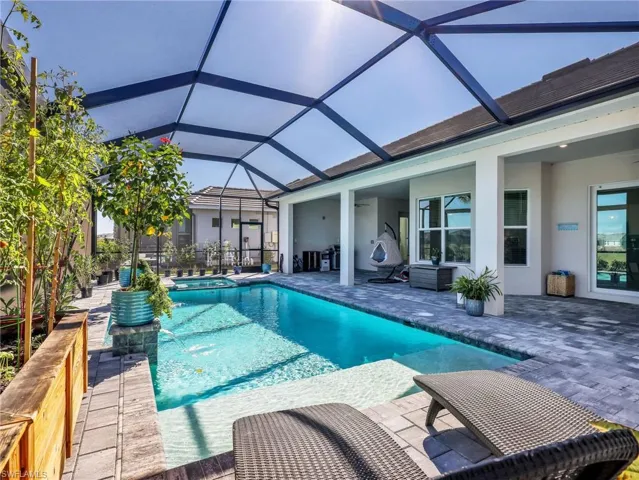 Integrated pool / hot tub featuring a patio, a sunroom, and a lanai