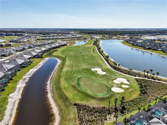 View of property location with nearby suburban area, a large body of water, and a golf club