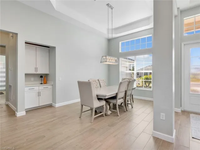 Dining area with light wood-type flooring and a raised ceiling
