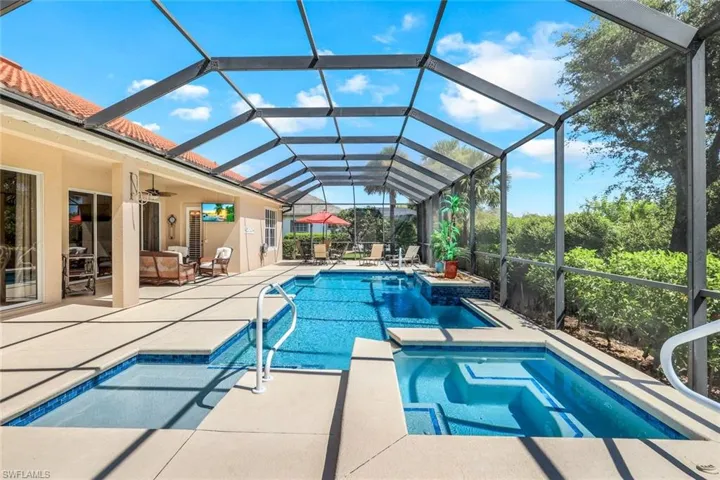 View of pool featuring an in ground hot tub, glass enclosure, a patio area, and ceiling fan