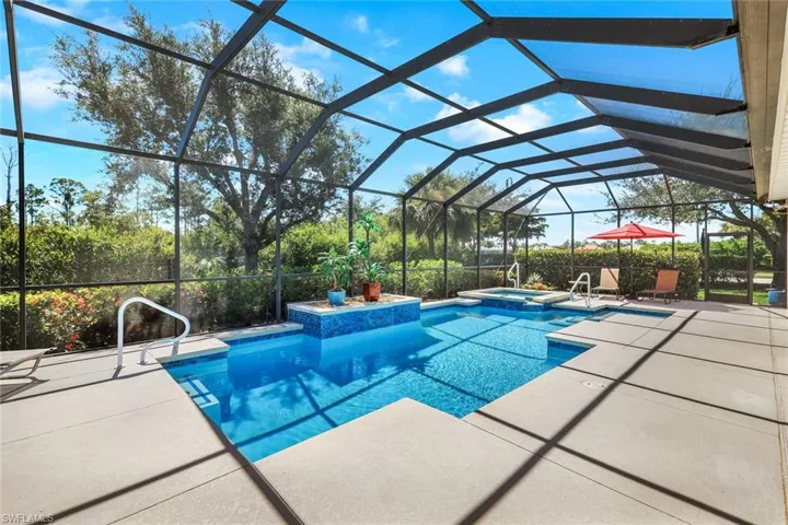 View of swimming pool featuring an in ground hot tub, a patio area, and a lanai