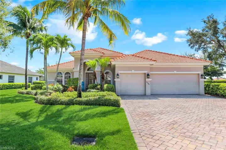 Mediterranean / spanish home featuring a garage and a front yard