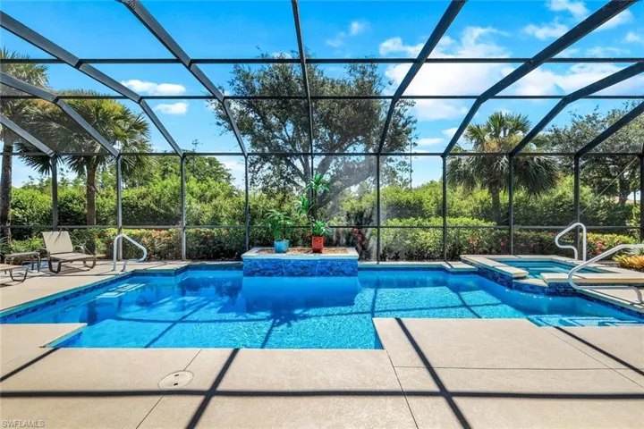 View of pool with an in ground hot tub, a patio area, and a lanai