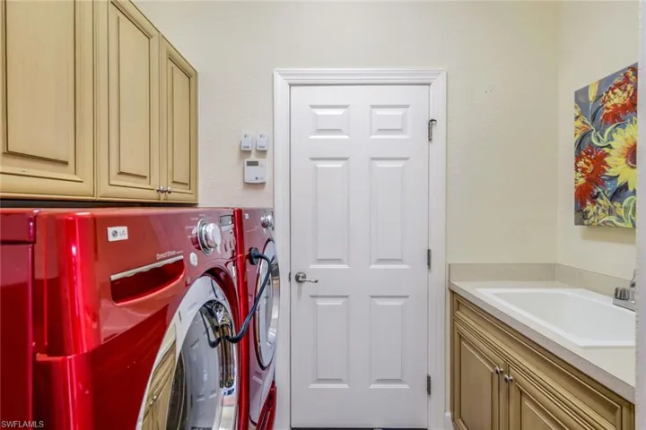 Washroom with cabinets, washer and dryer, and sink
