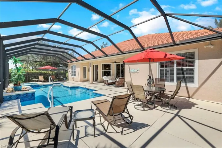 View of swimming pool with a hot tub, glass enclosure, a patio area, and ceiling fan
