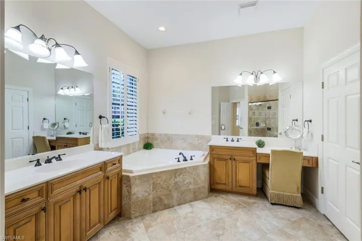 Bathroom with tile patterned floors, separate shower and tub, and double vanity