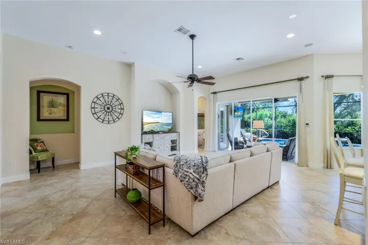 Living room with ceiling fan and light tile patterned floors