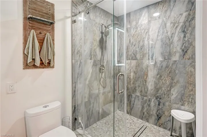 Full bath with toilet and a shower stall