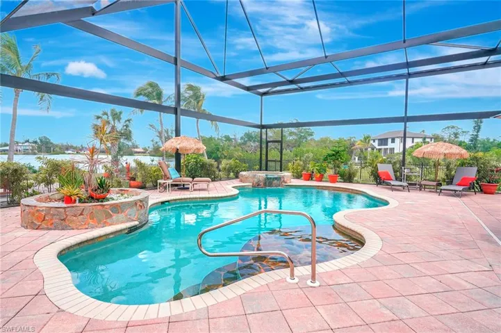 View of swimming pool featuring a pool with connected hot tub, a lanai, and a patio