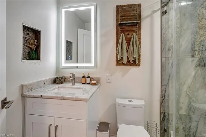 Full bath featuring toilet, vanity, and a shower stall