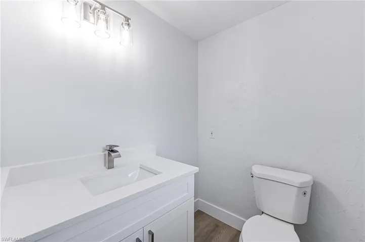 Bathroom featuring vanity, hardwood / wood-style flooring, and toilet