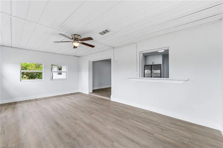 Empty room with hardwood / wood-style floors and ceiling fan