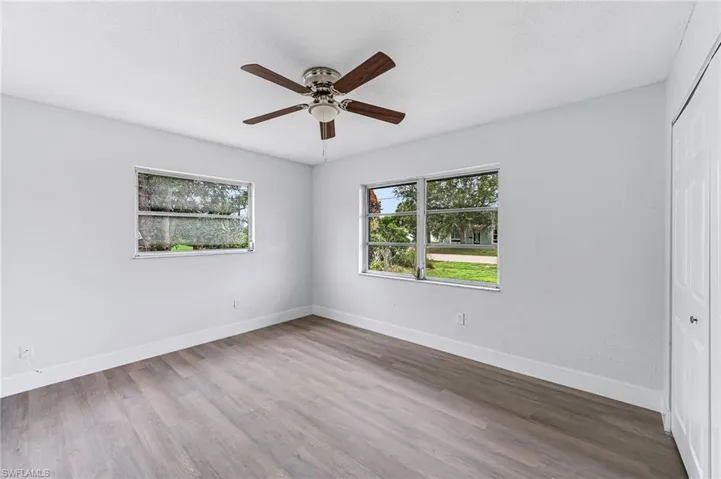 Unfurnished bedroom with ceiling fan, wood-type flooring, and a closet